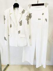 White suit with decorative elements on a hanger against a white background