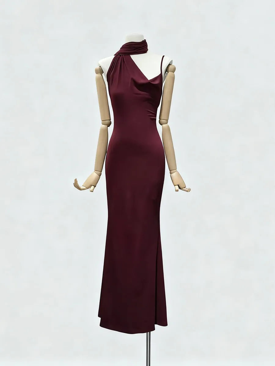 Wine red evening gown on a mannequin against a white background