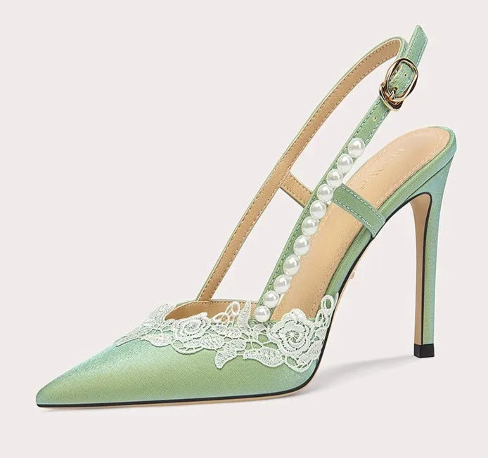 Green high-heeled shoe with lace detail on a white background