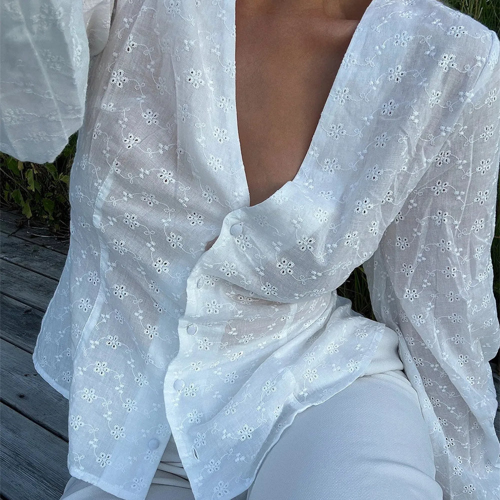 White floral dress with a deep neckline on a wooden deck