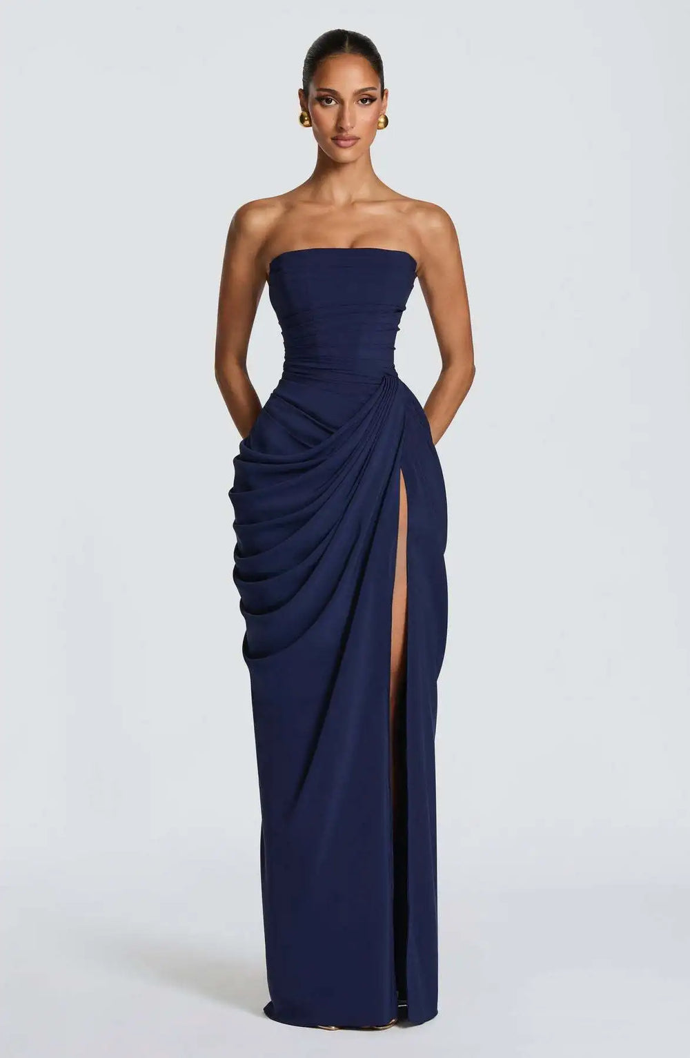 Navy strapless gown with a slit on a white background