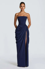 Navy strapless gown with a slit on a white background