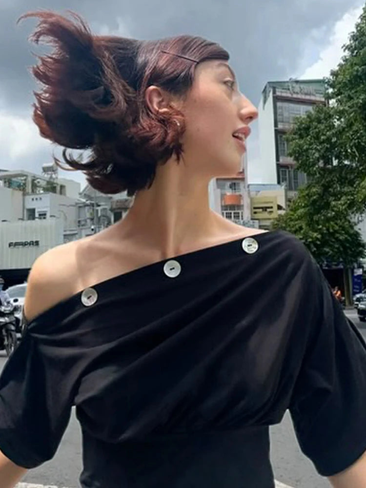 Profile view of woman wearing black one shoulder top