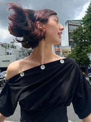 Profile view of woman wearing black one shoulder top