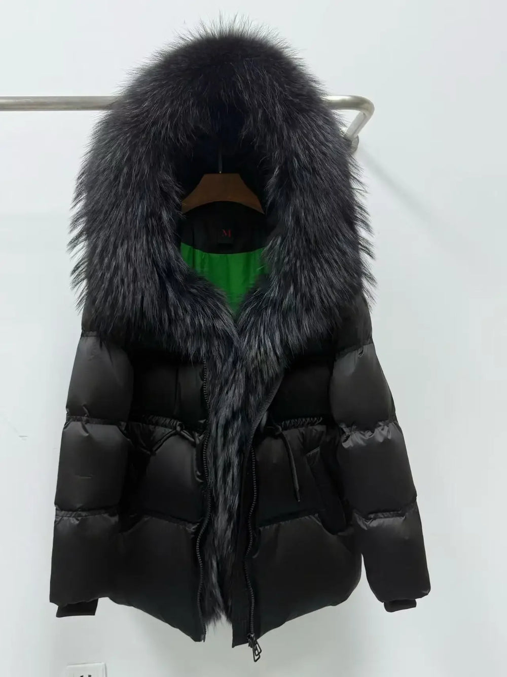 Black puffer jacket with fur hood on a white background