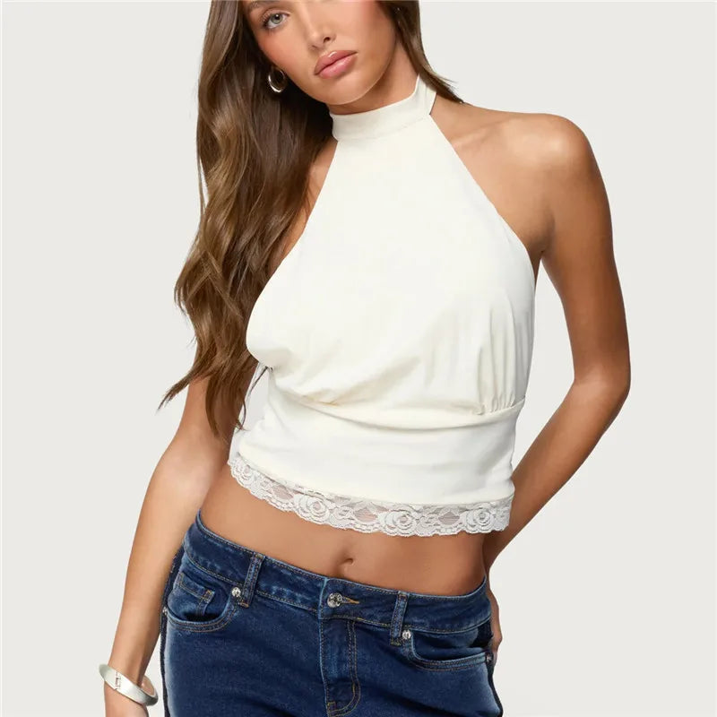 Woman wearing a white halter top with lace detail and blue jeans on a white background