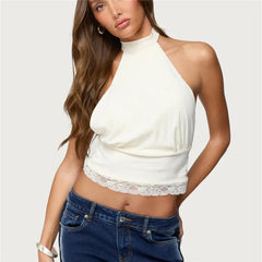 Woman wearing a white halter top with lace detail and blue jeans on a white background