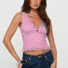 Woman wearing a pink polka dot top and blue jeans on a white background