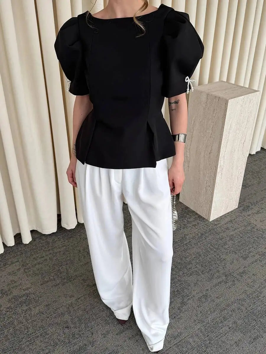 Full body view of black puff sleeve peplum blouse