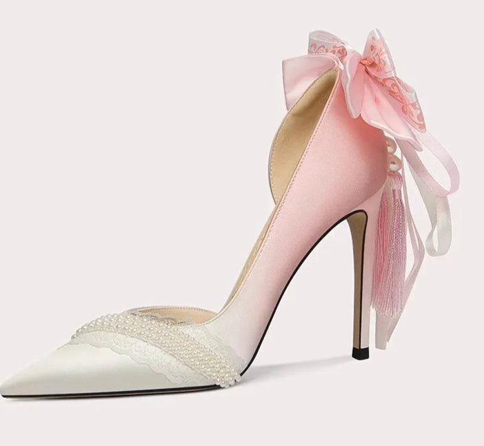 High-heeled shoe with a pink bow on a light gray background