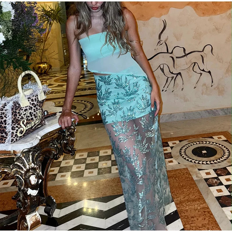 Person wearing a turquoise outfit with a decorative background