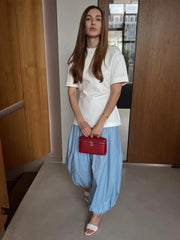 Woman holding a red handbag in an indoor setting