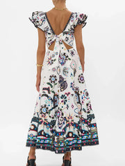 Woman wearing a colorful patterned dress with a back tie 