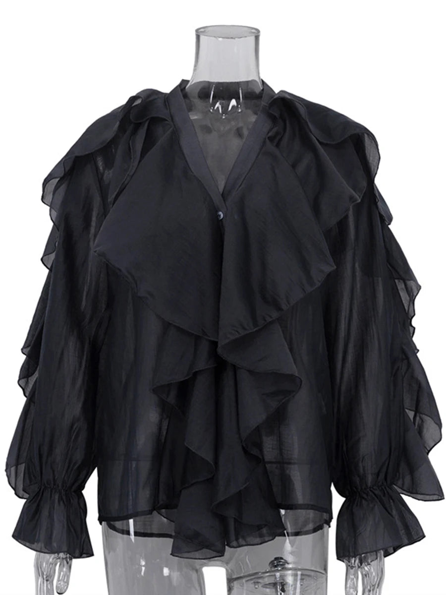 Black ruffled blouse on a mannequin against a white background