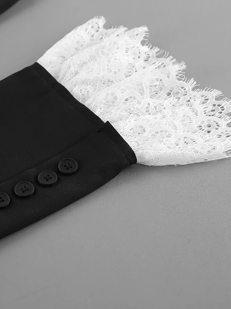 Close-up of a black garment with white lace trim on a gray background
