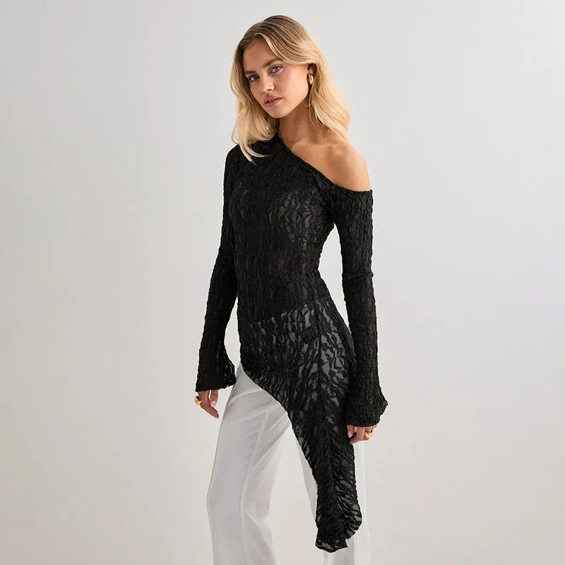 Woman wearing a black lace dress against a light gray background