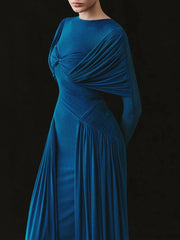 Blue evening gown with draped design on a black background
