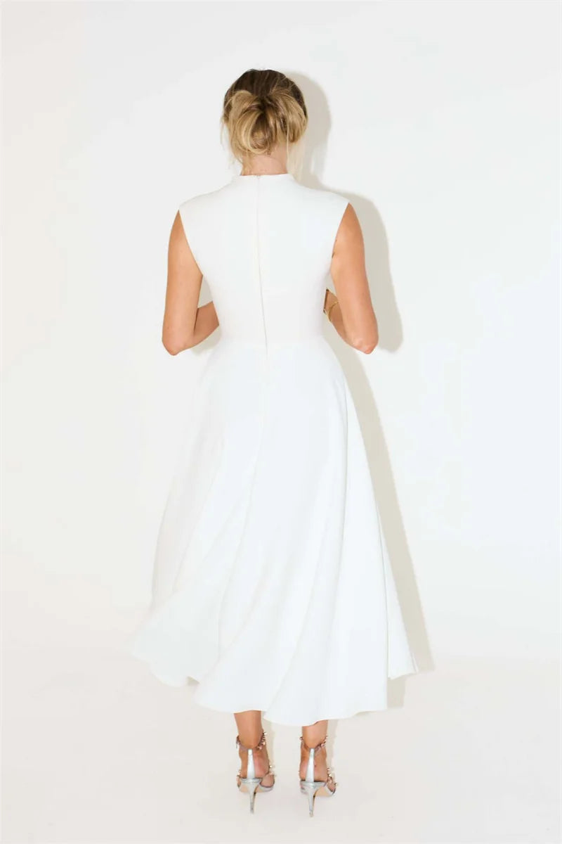 Woman wearing a white dress with cut-out shoulders on a white background