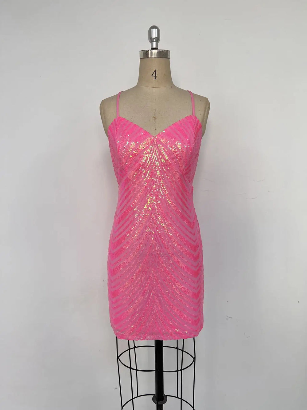 Pink sequin dress on a mannequin against a gray background