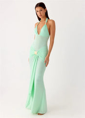 Woman wearing a mint green evening gown on a white background