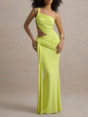 Woman wearing a bright green one-shoulder dress against a beige background