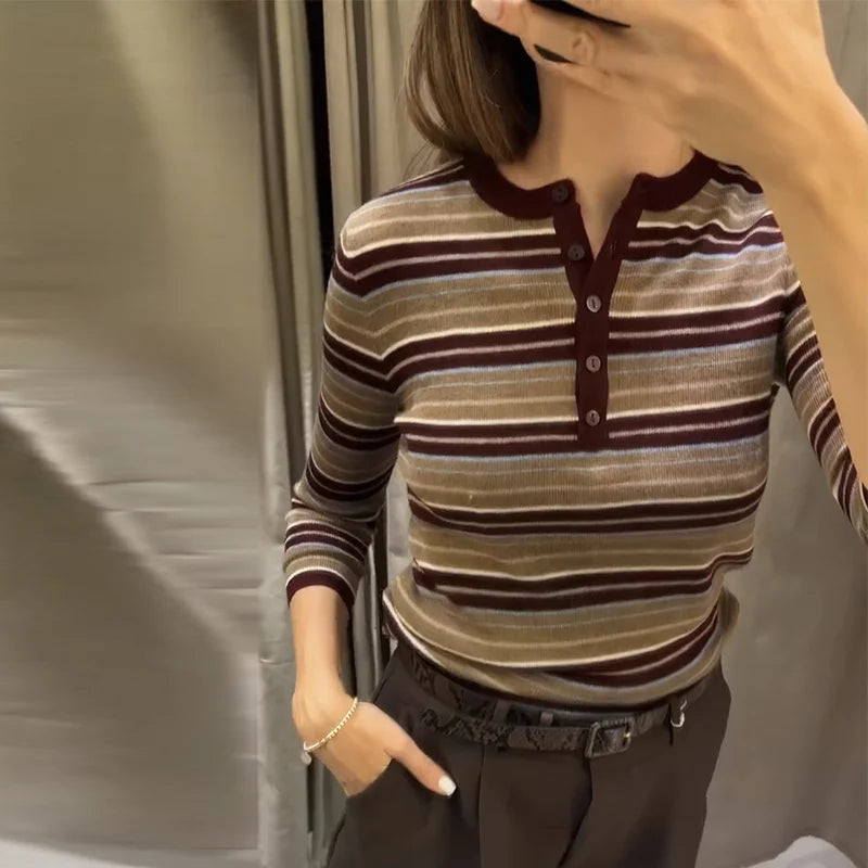 Person wearing a striped long-sleeve shirt with a blurred background