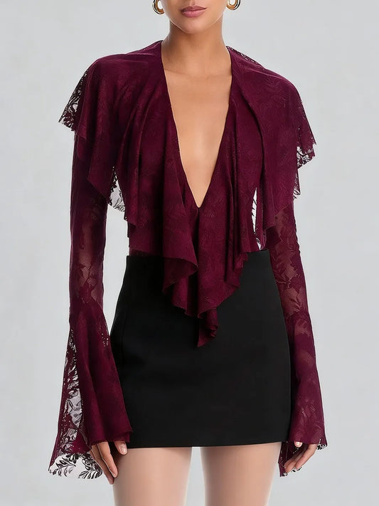 Maroon lace top with long sleeves and a black skirt on a plain background