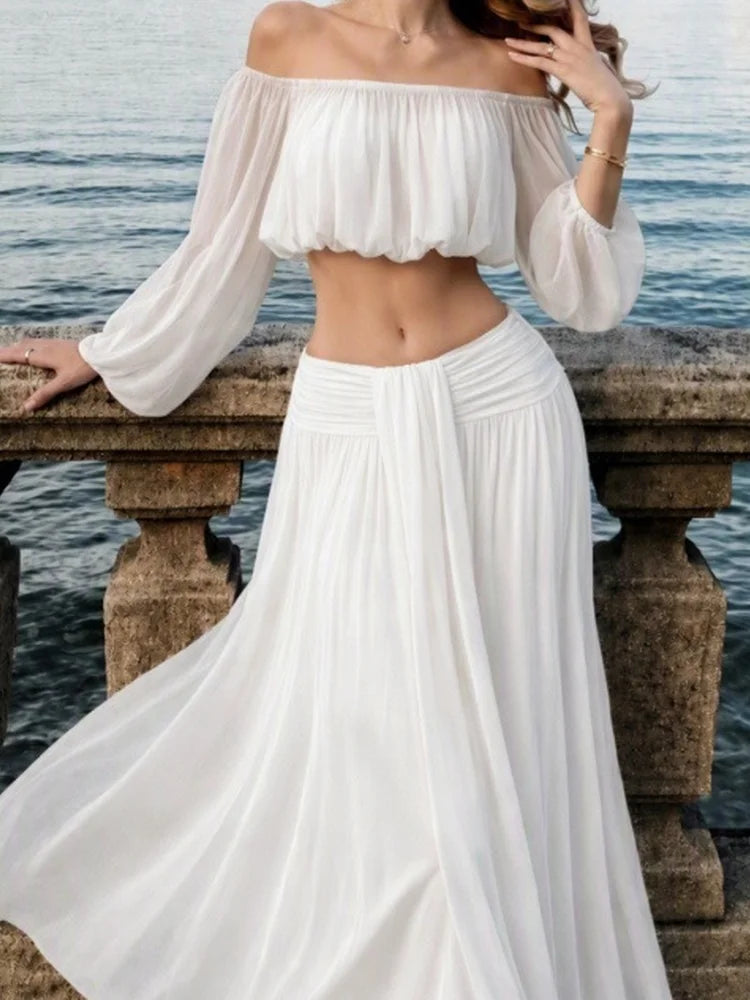 White off-shoulder chiffon crop top and maxi skirt with ruched waist detail.