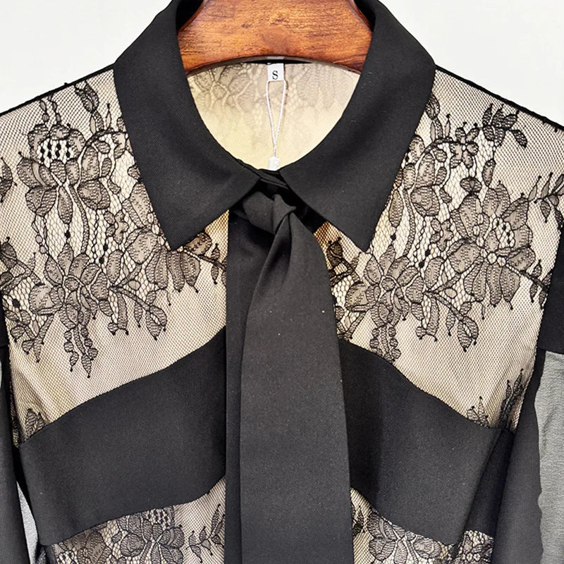Black lace blouse with a tie collar on a hanger