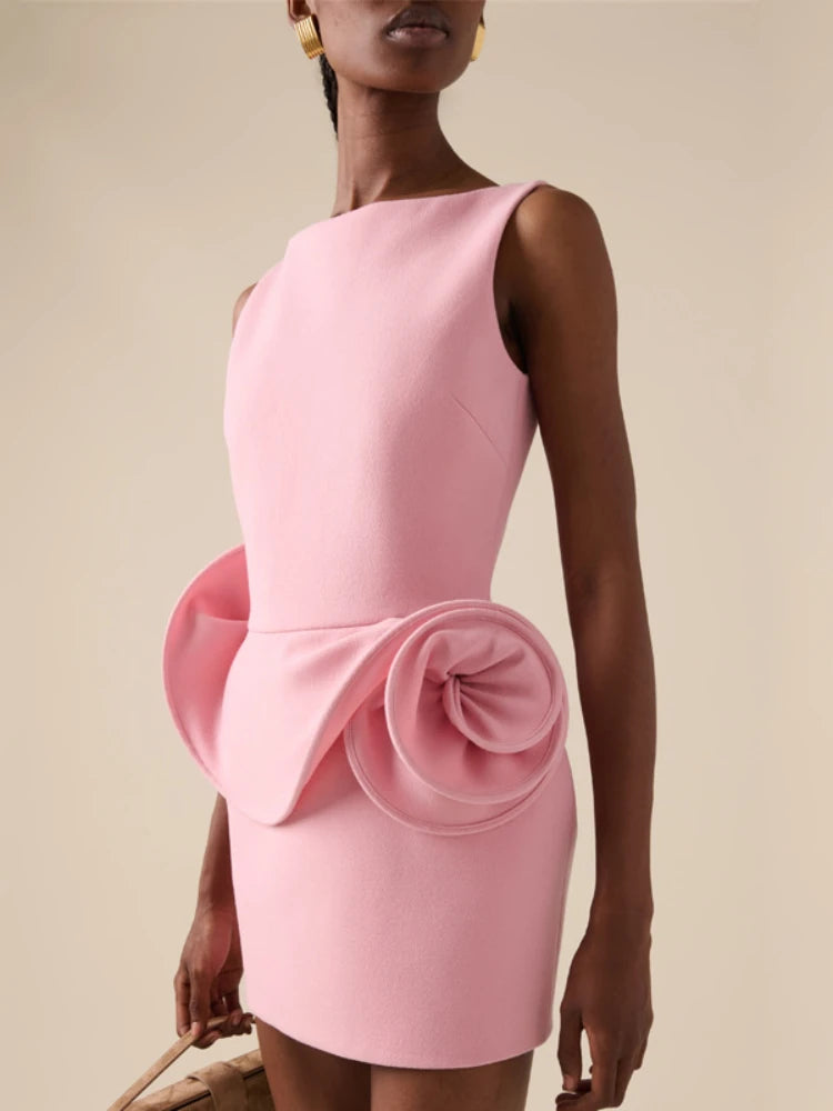 Pink dress with a large bow detail on a beige background