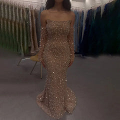 Woman wearing a sparkly strapless gown in a fitting room with other dresses.