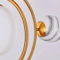 Close-up of a ceiling light fixture with gold and marble design on a white background.