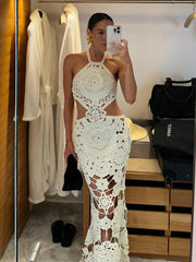 Woman taking a mirror selfie wearing a white lace dress in a room with wooden flooring.