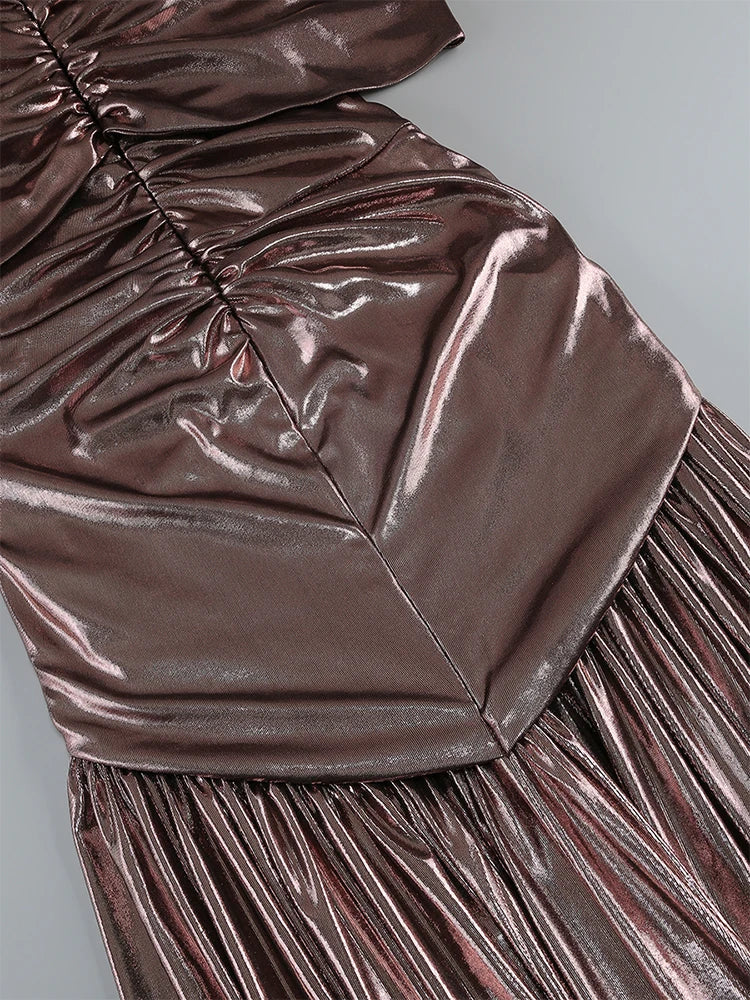 Close-up of a metallic brown dress with pleated details on a gray background