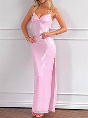 Woman wearing a pink sequin dress against a white wall.