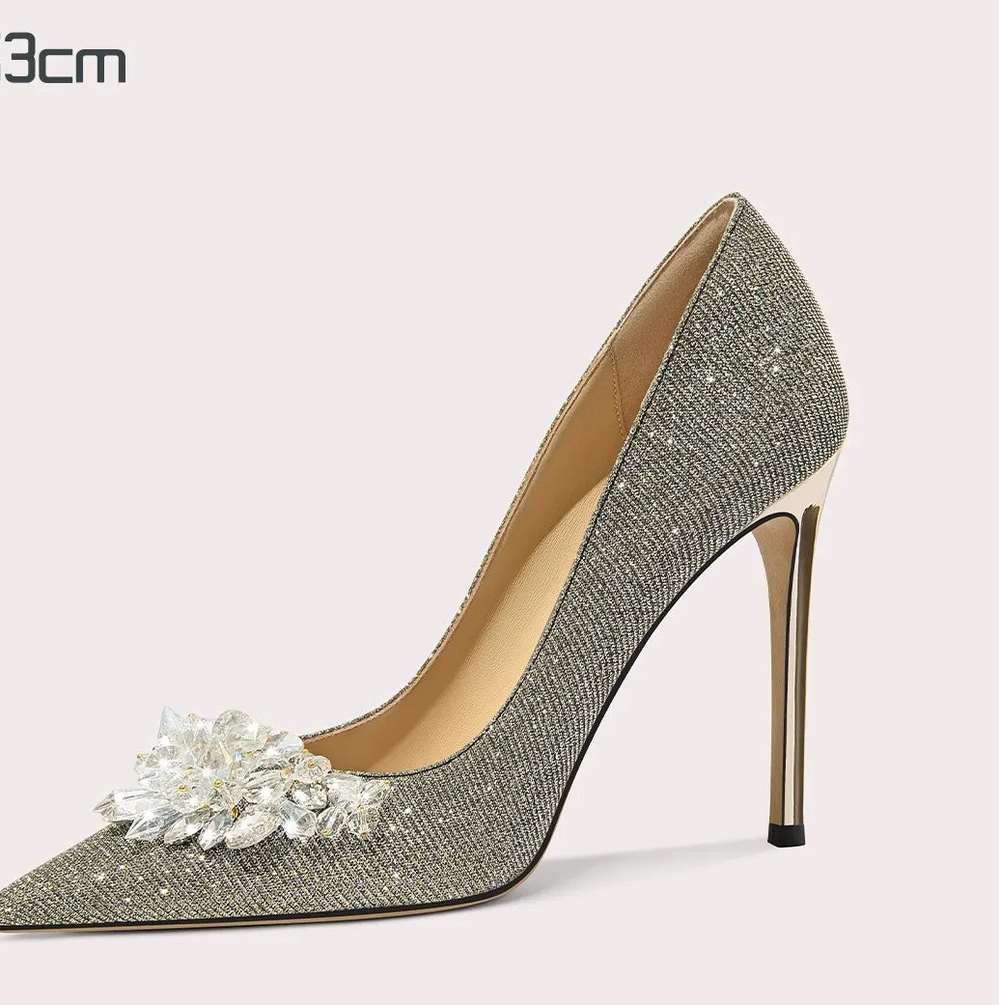 Silver high-heeled shoe with floral design on a light gray background