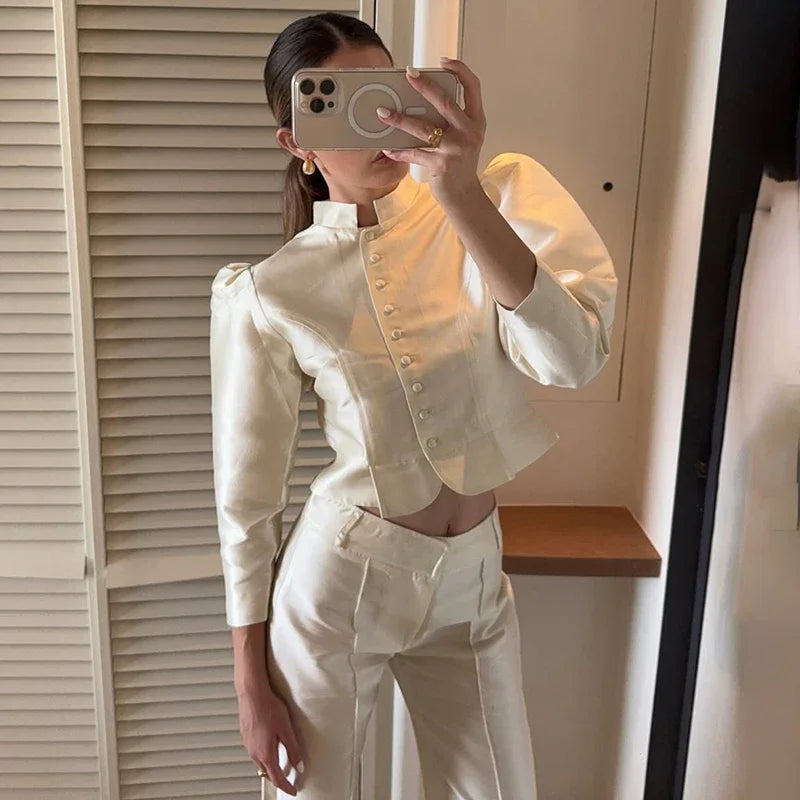 Person wearing a white outfit taking a mirror selfie.