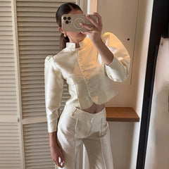 Person wearing a white outfit taking a mirror selfie.
