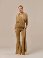 Full body shot of a woman wearing a tan draped halter top and matching wide leg pants set.