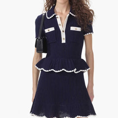 Woman wearing a navy blue dress with white trim on a white background