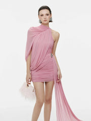 Woman wearing a pink dress with a flowing fabric on a white background