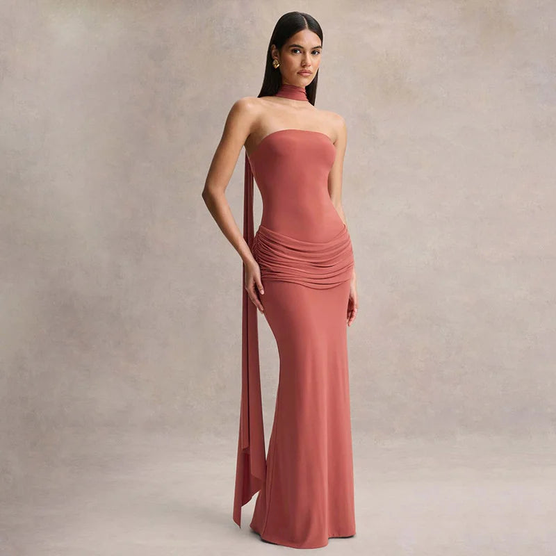 Woman wearing a long, strapless pink dress against a neutral background