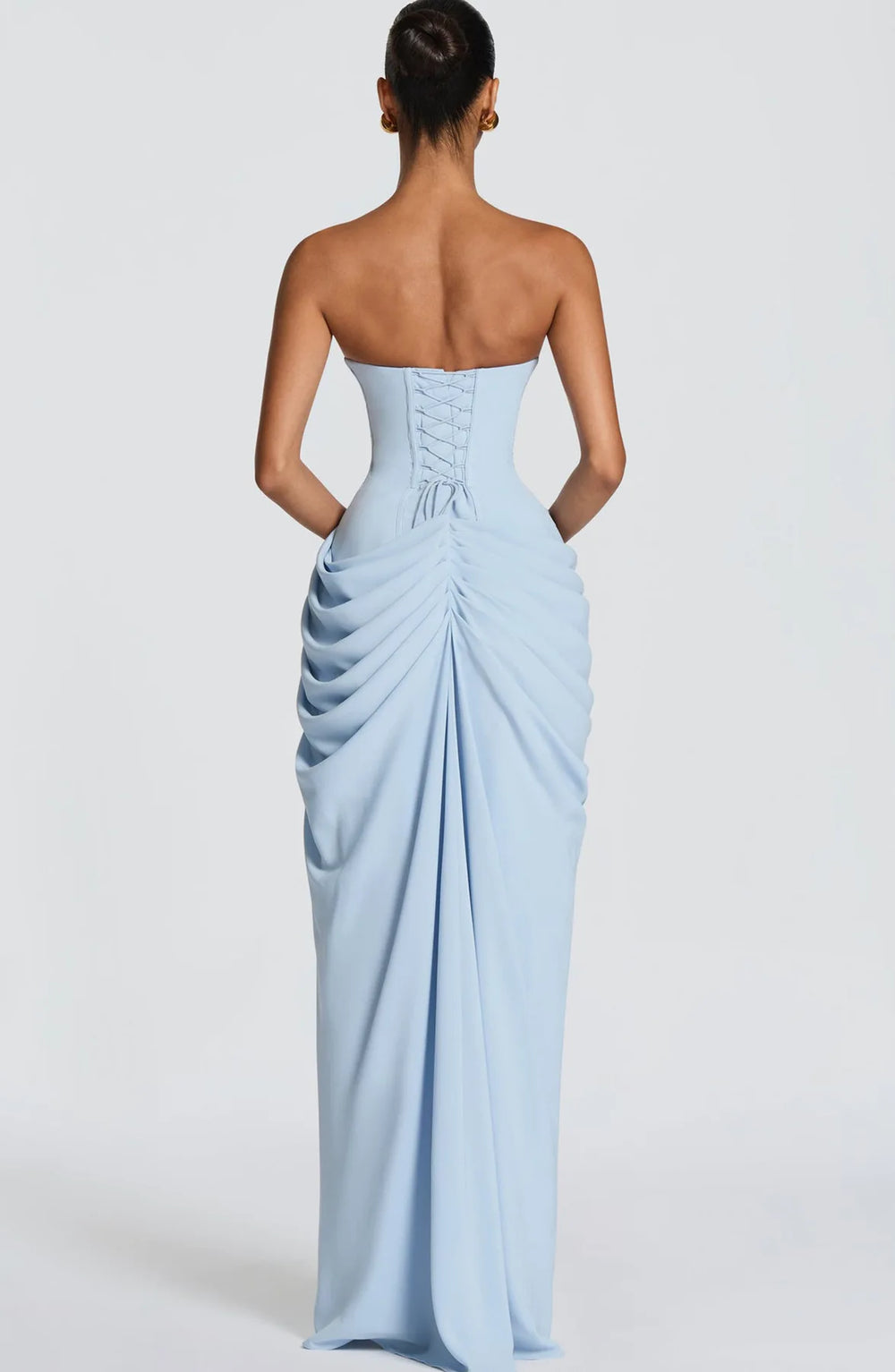Woman wearing a light blue strapless gown on a white background