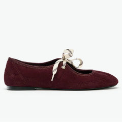 Side profile of burgundy faux suede round toe ballet flats with lace-up detail.