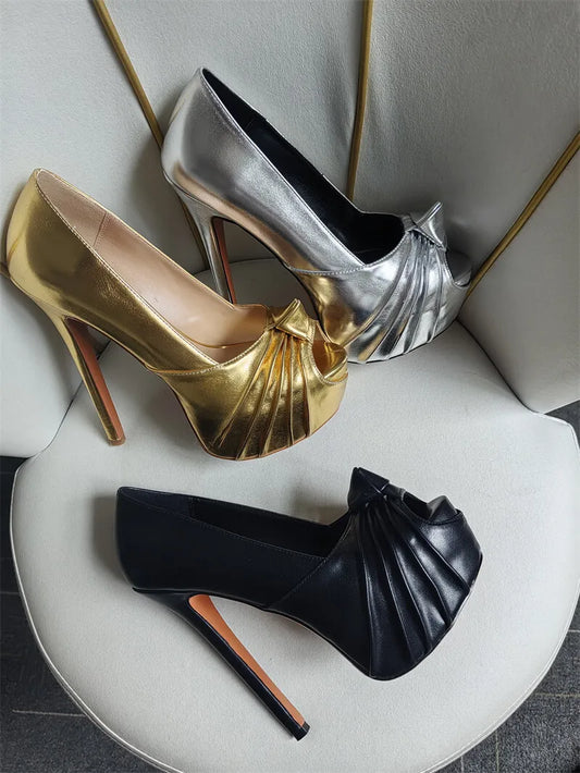 Gold and silver platform stiletto peep toe heels arranged on a chair.