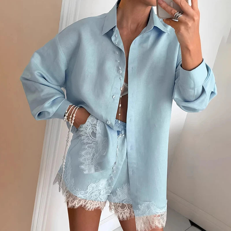 Light blue denim shirt with lace trim worn by a person, against a neutral background.