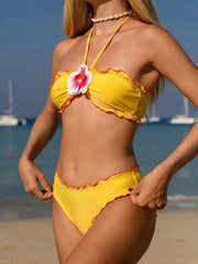 Model wearing the embellished swimwear set on the beach.