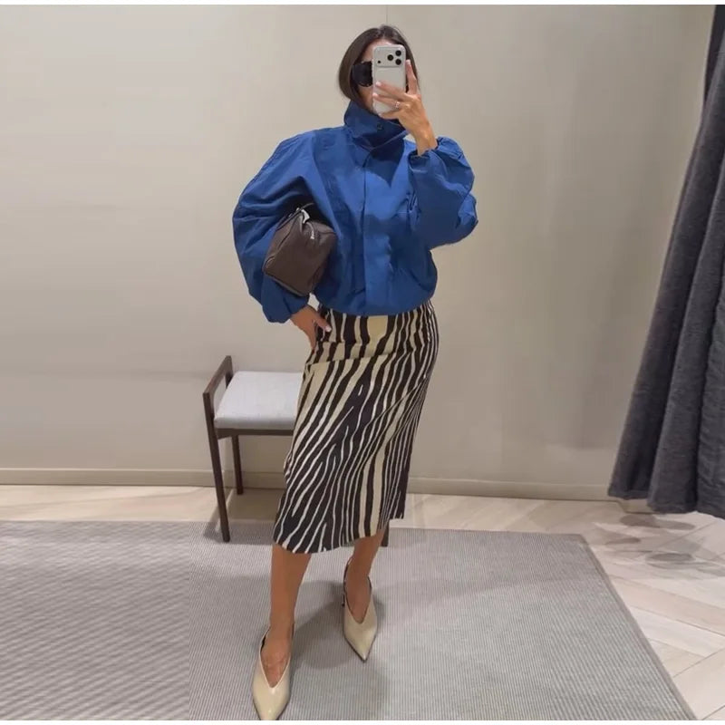 Woman wearing a blue jacket and zebra print straight midi skirt