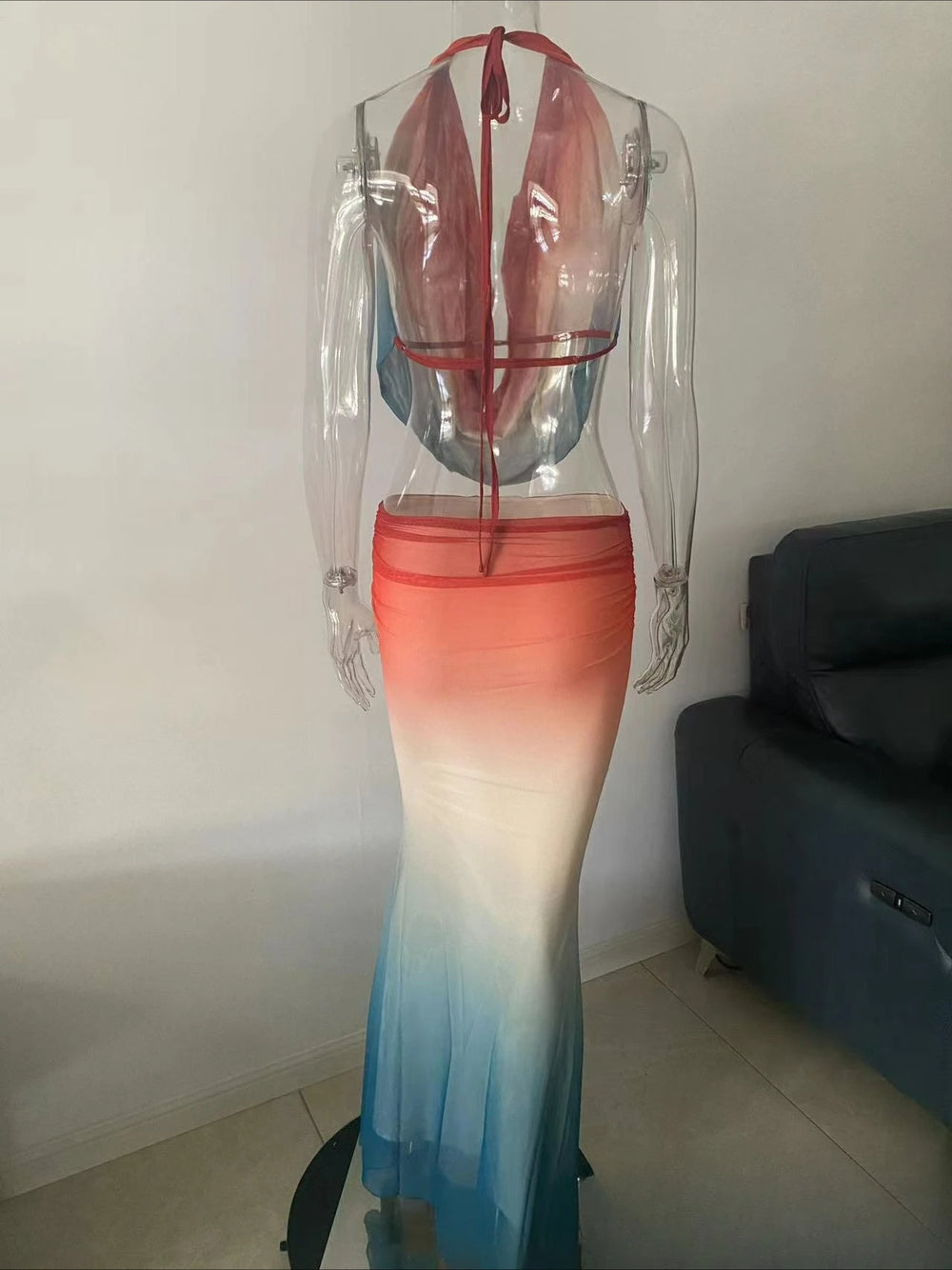 Gradient dress on a mannequin against a plain wall.