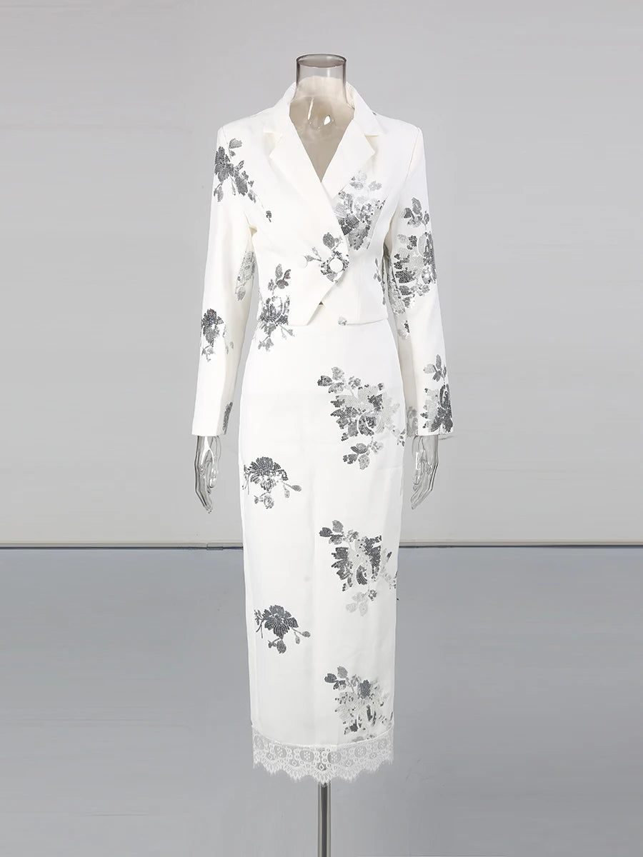 White dress with floral patterns on a mannequin against a gray background